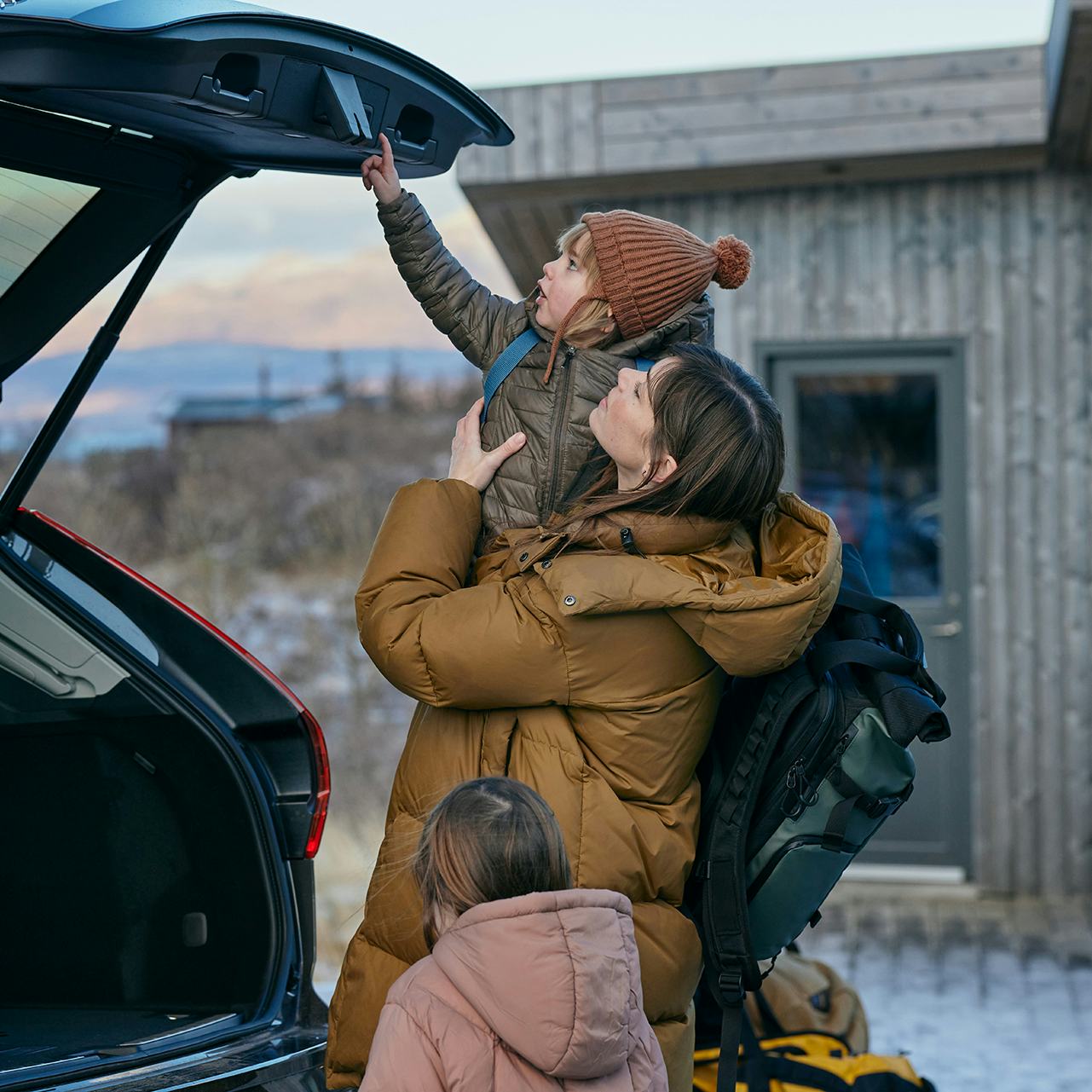 Móðir með börn við bíl