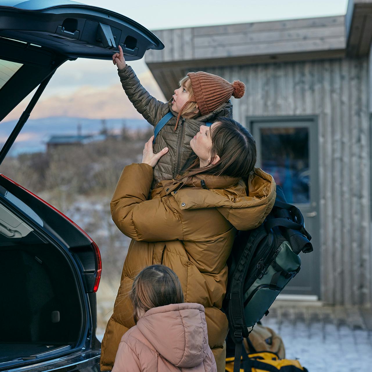 Móðir með börn við bíl