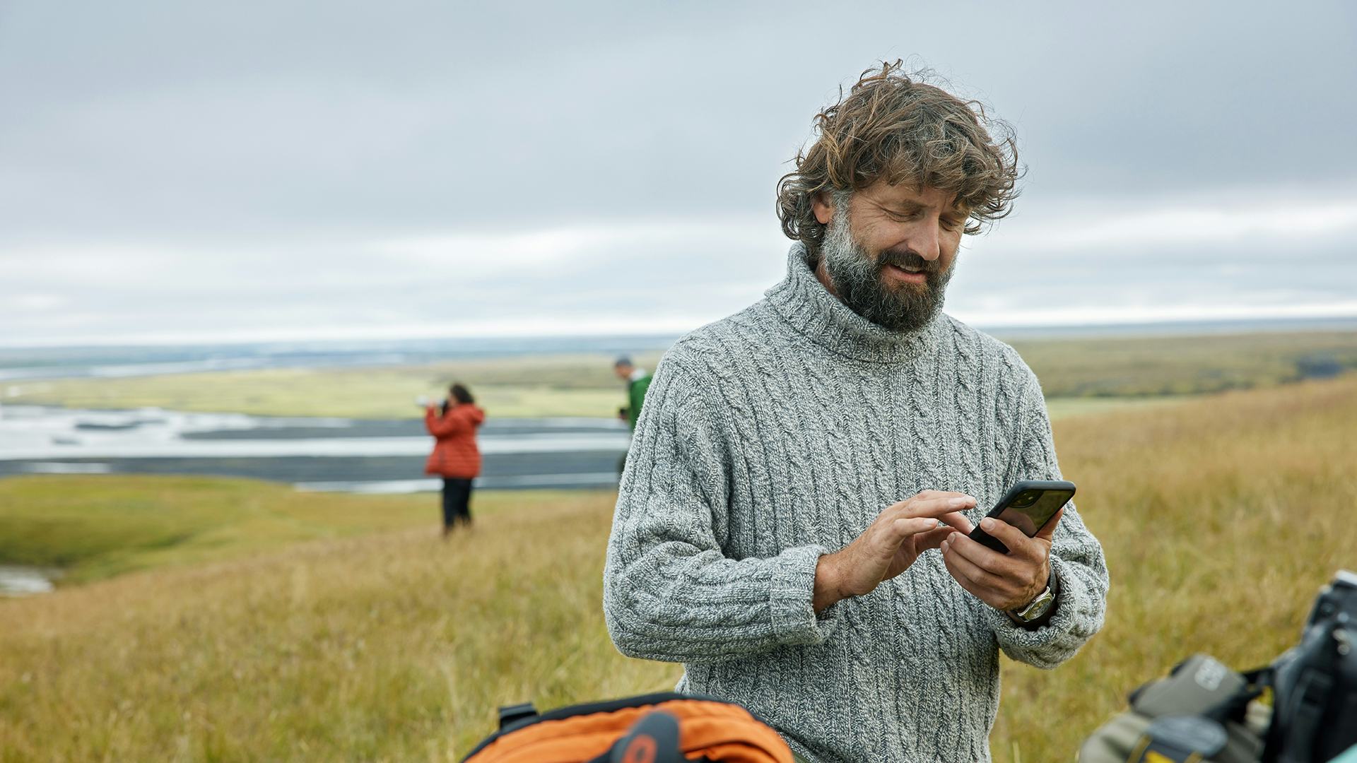 Maður með síma úti í náttúrunni