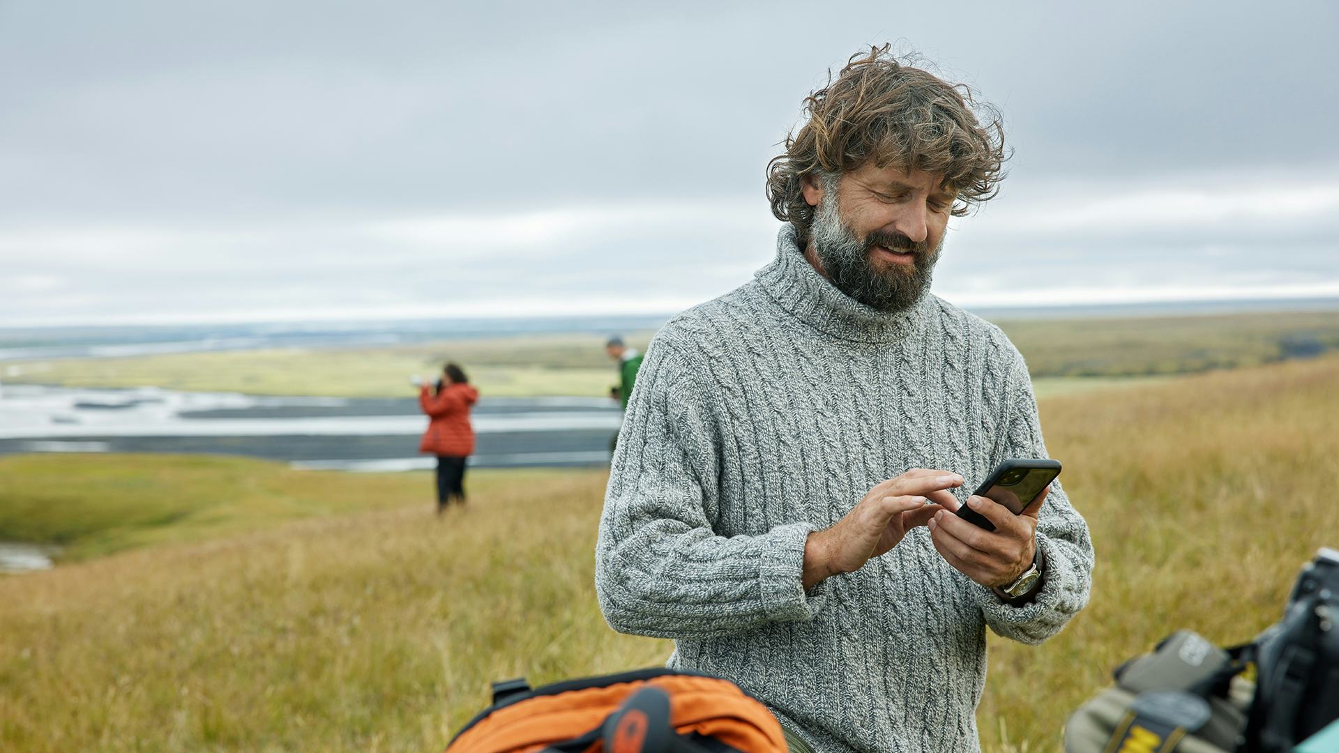 Maður með síma úti í náttúrunni