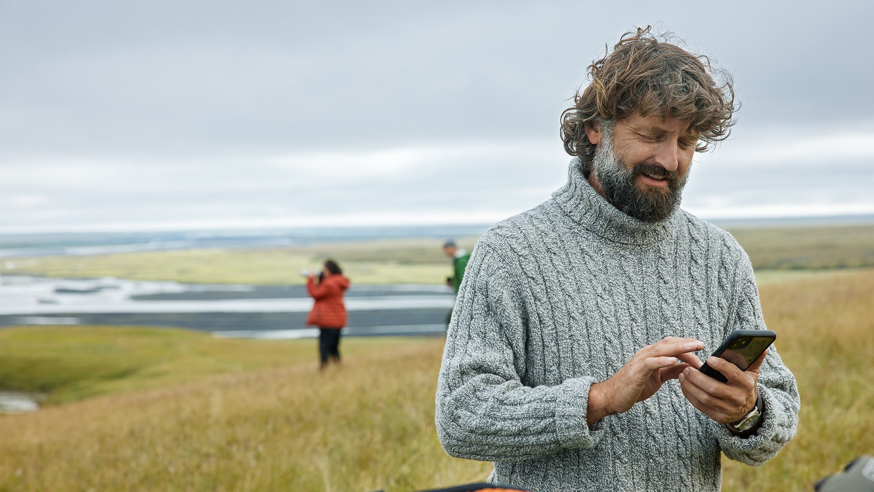 Maður með síma úti í náttúrunni