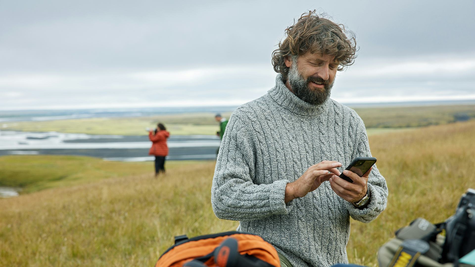 Maður með síma úti í náttúrunni