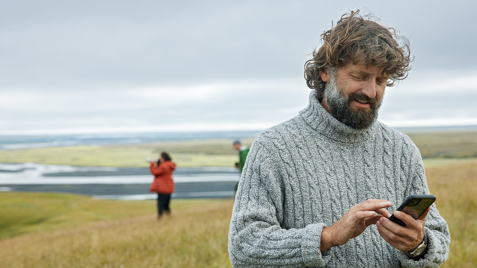 Maður með síma úti í náttúrunni