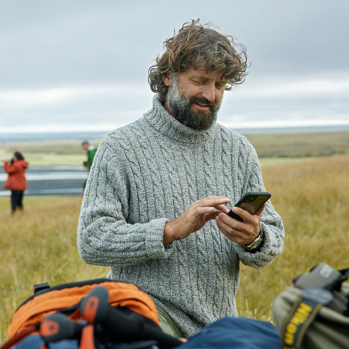 Maður með síma úti í náttúrunni