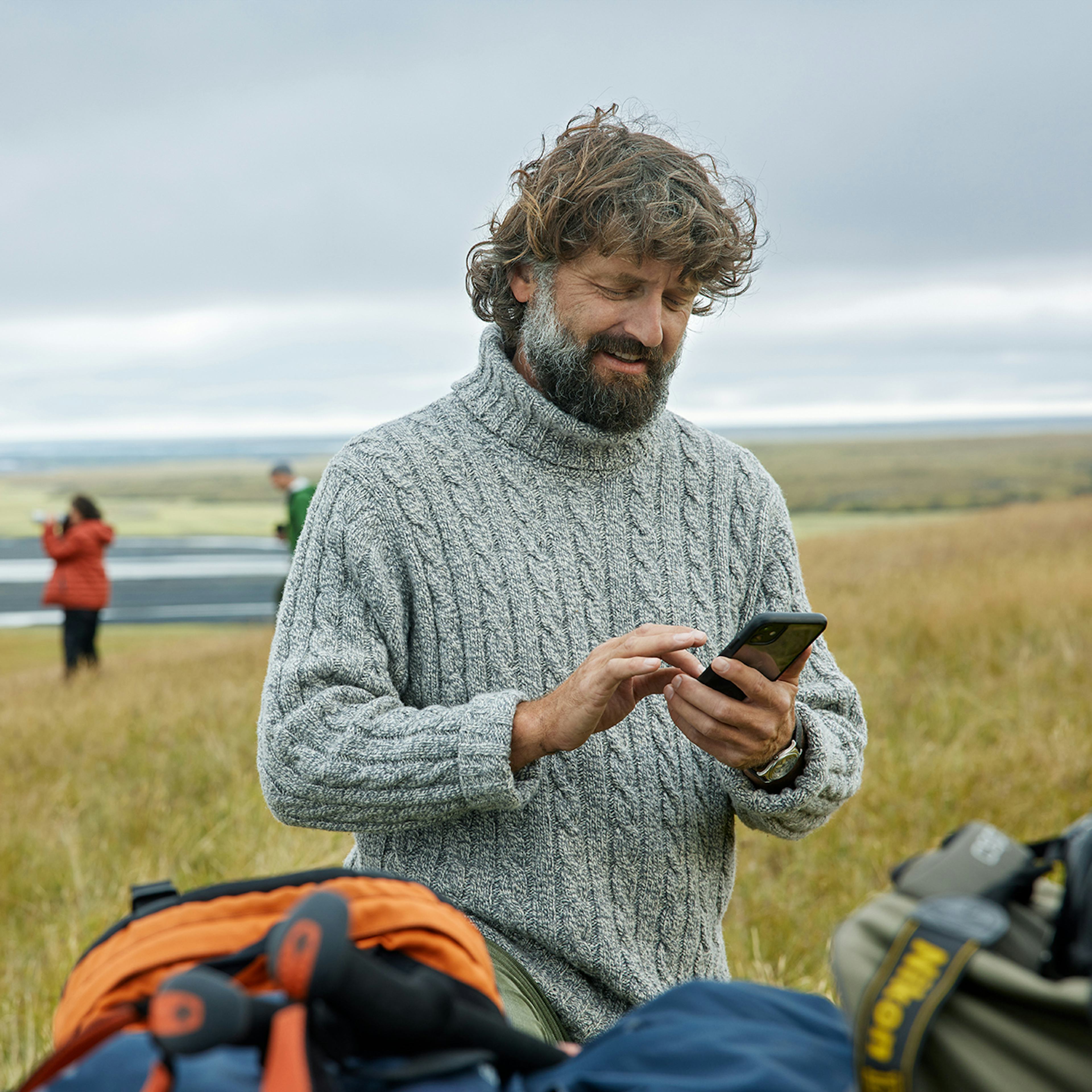 Maður með síma úti í náttúrunni