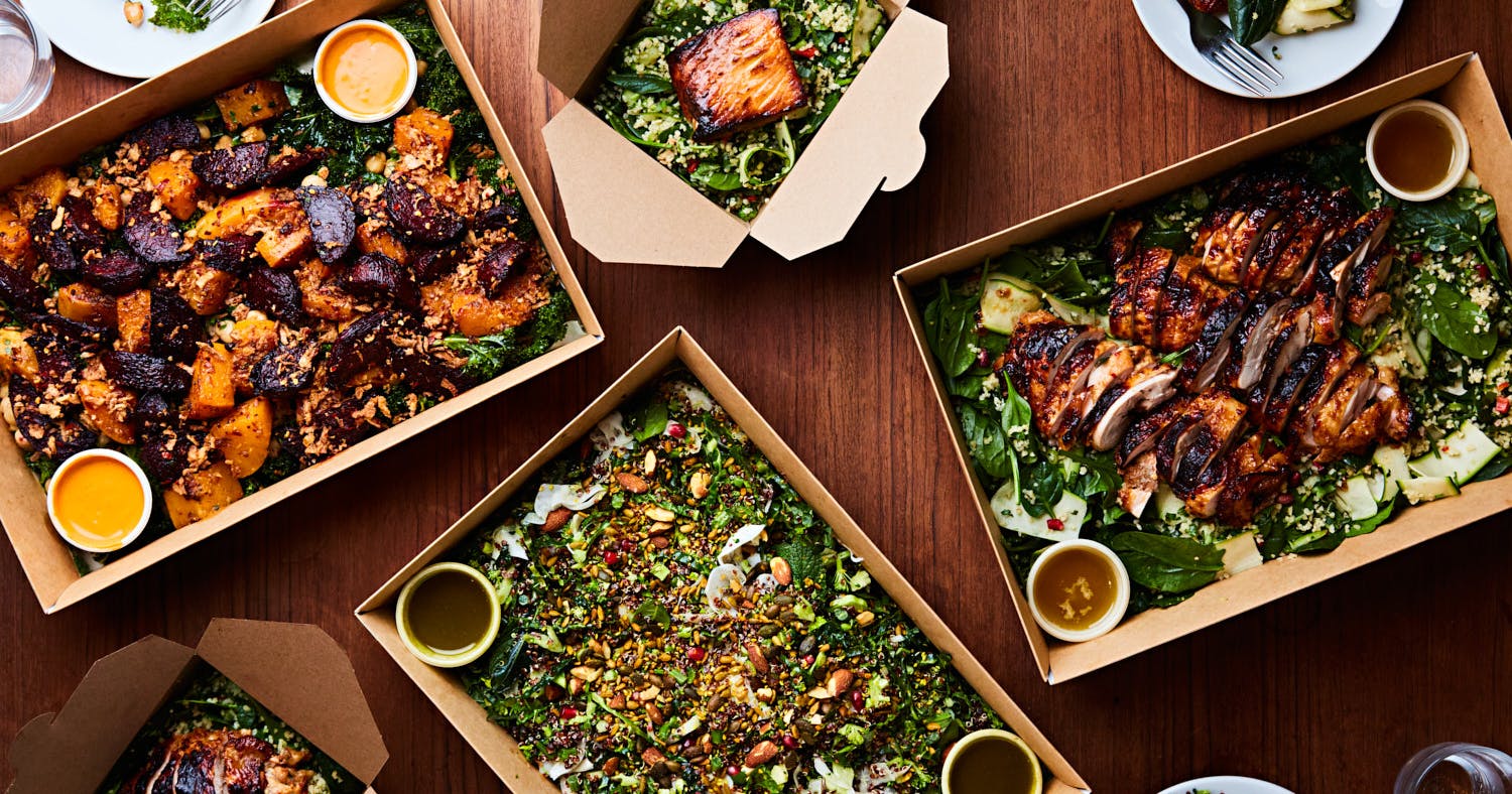 Top-down view of Lantana’s workplace catering lunchboxes featuring spiced chicken thigh with salad, baked salmon with greens and grains, and a vibrant harissa roasted squash and beetroot salad—freshly prepared and ready for carbon-free delivery
