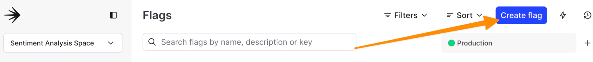 The image shows the Flags management interface within LaunchDarkly. On the left side, the selected project is "Sentiment Analysis Space." In the main area, there is a search bar labeled "Search flags by name, description, or key," and the environment is set to "Production," indicated by a green dot. An orange arrow points to a blue "Create flag" button located in the top-right corner, indicating the action to create a new feature flag.