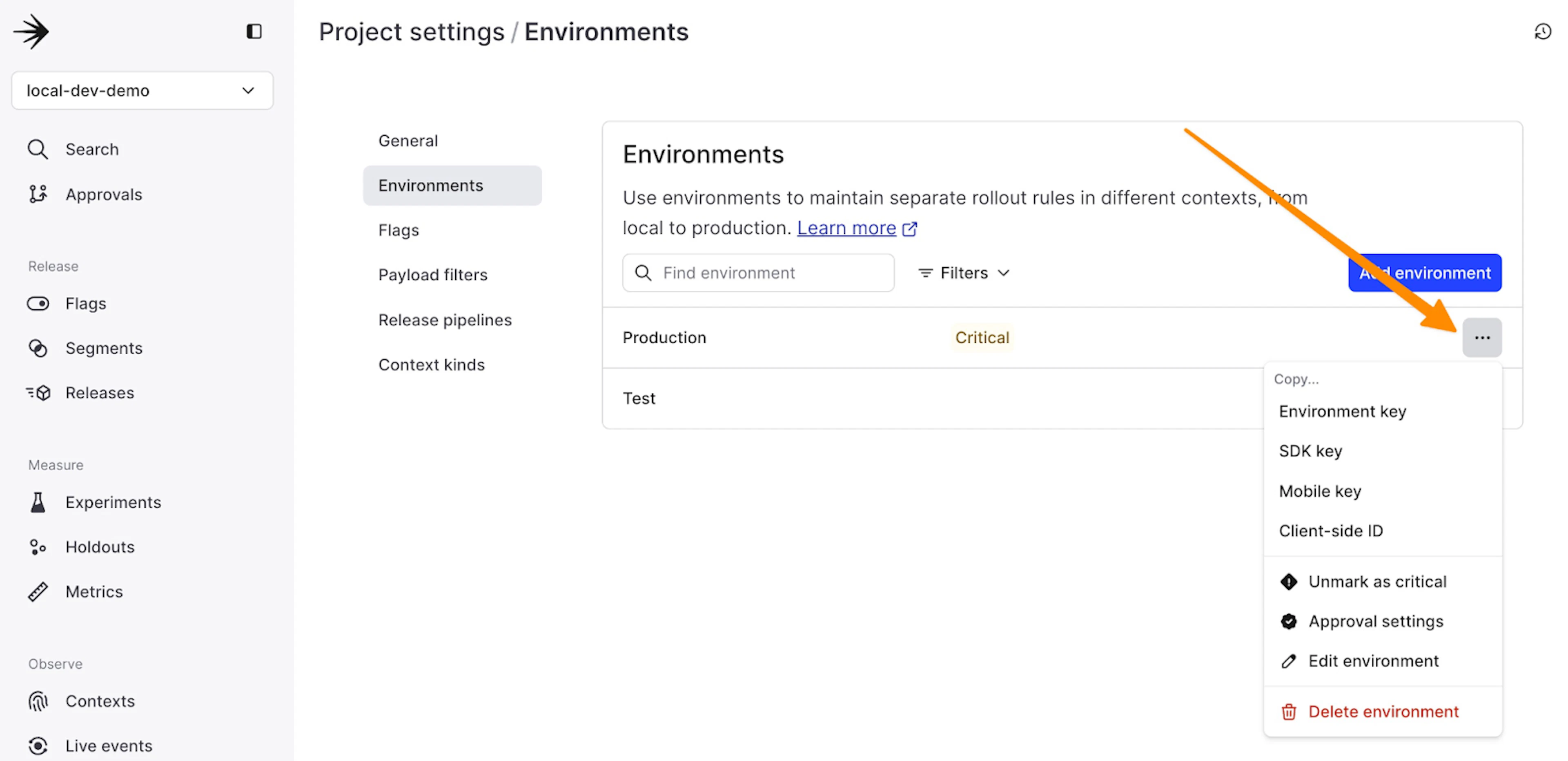 LaunchDarkly project settings showing environment configuration with an arrow pointing to the options menu for environment keys and settings.