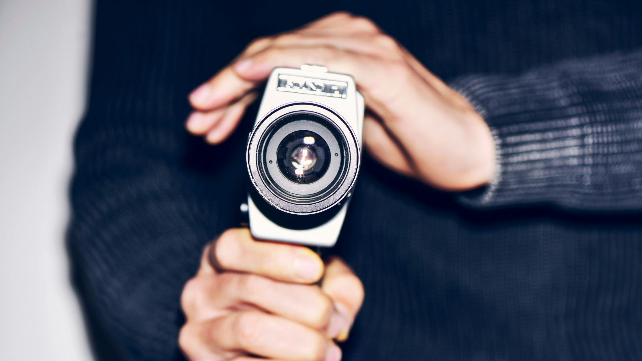 person's hands holding a vintage camera 