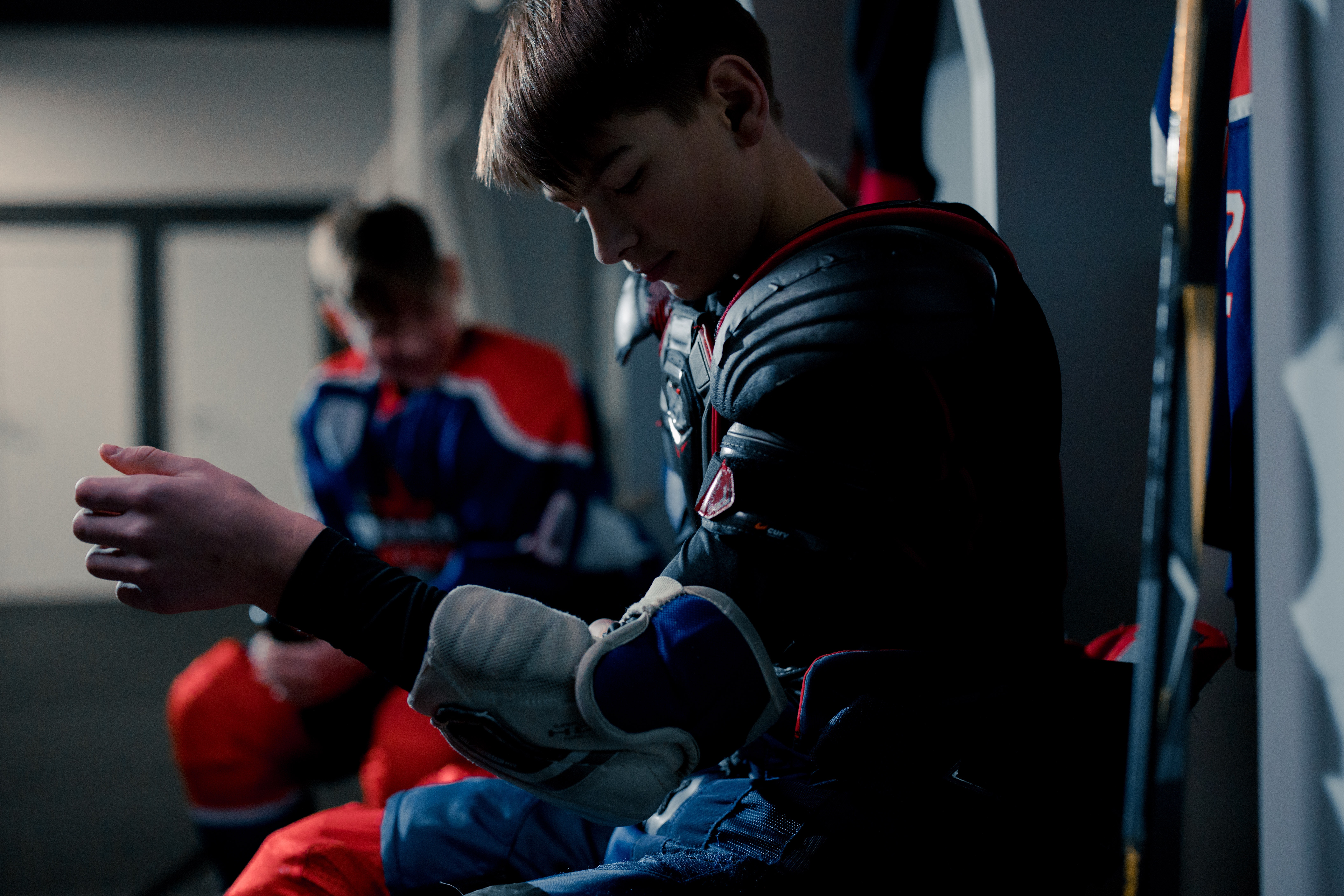 Boy putting on hockey equipment