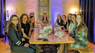 A photo of the summer crew sitting around a table in a restaurant