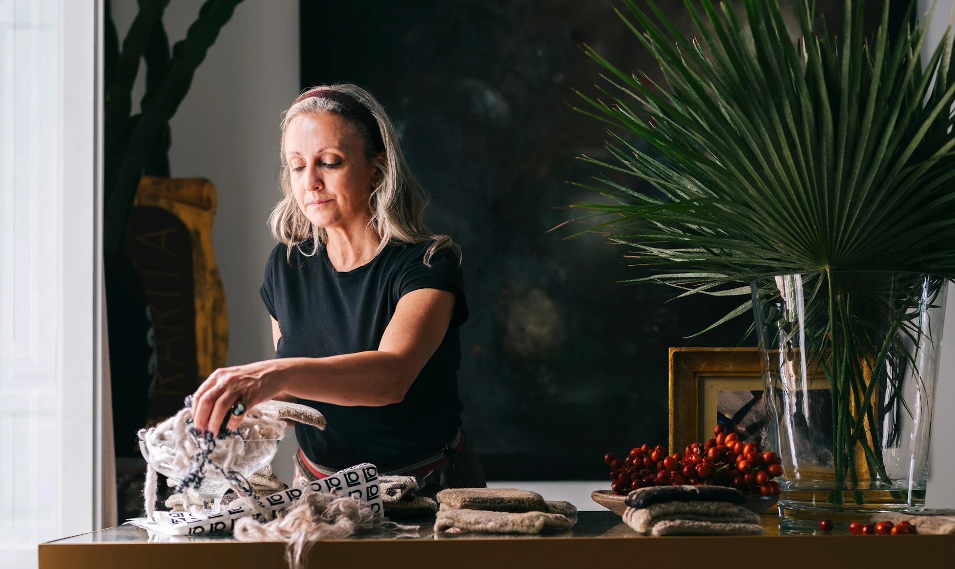 Portrait of founder Mariella Ienna in a refined interior with textiles, conveying her role as Italian designer working between Italy and India.