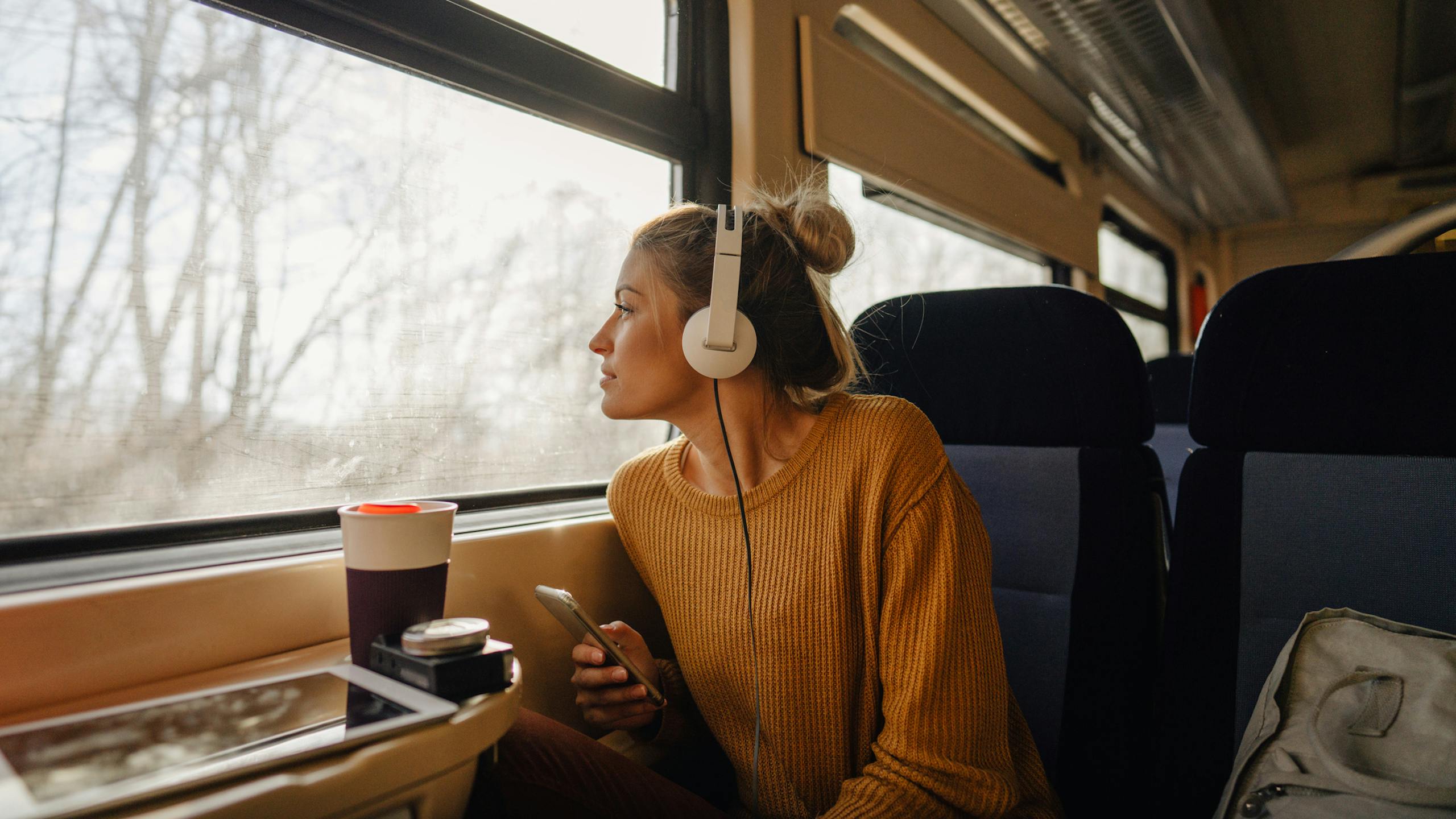 Jeune femme regardant le paysage défiler à bord d'un train