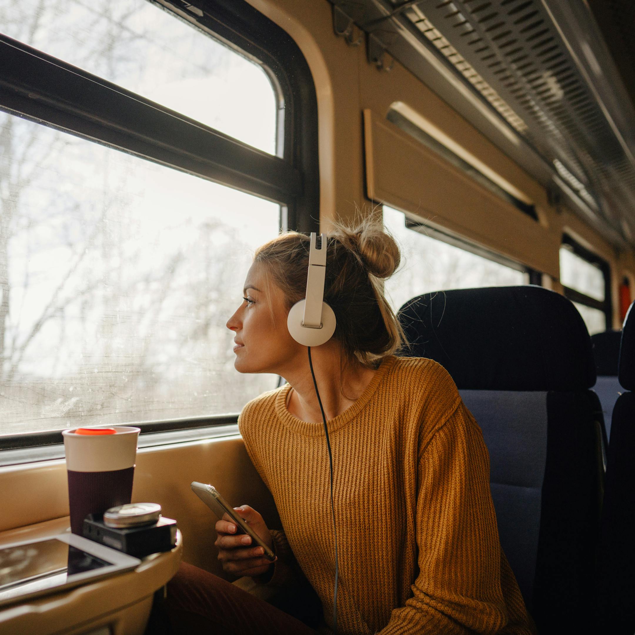Jeune femme regardant le paysage défiler à bord d'un train