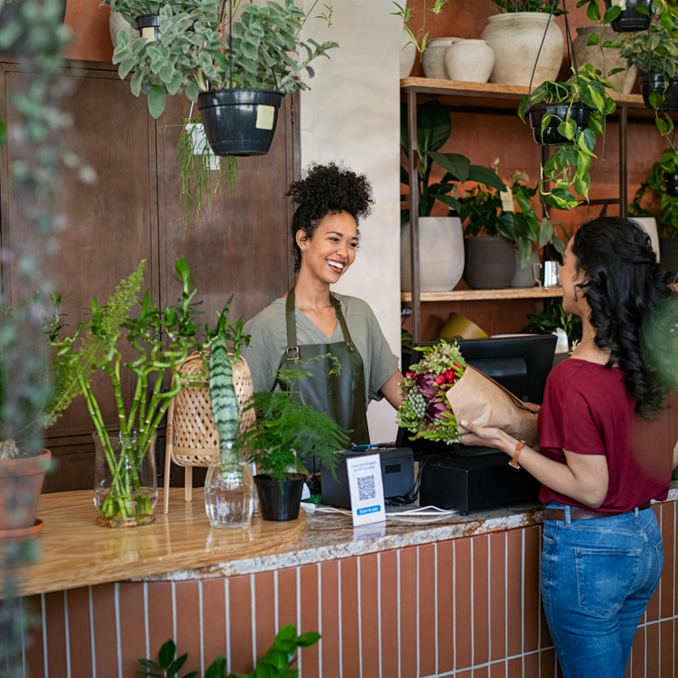 Fleuriste vendant des plantes et des fleurs à une cliente