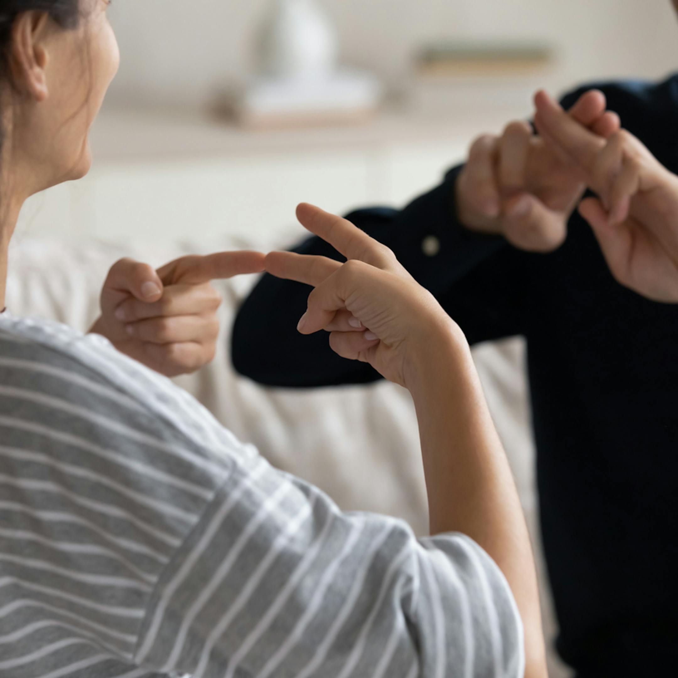 Couple communiquant à la maison en utilisant la langue des signes
