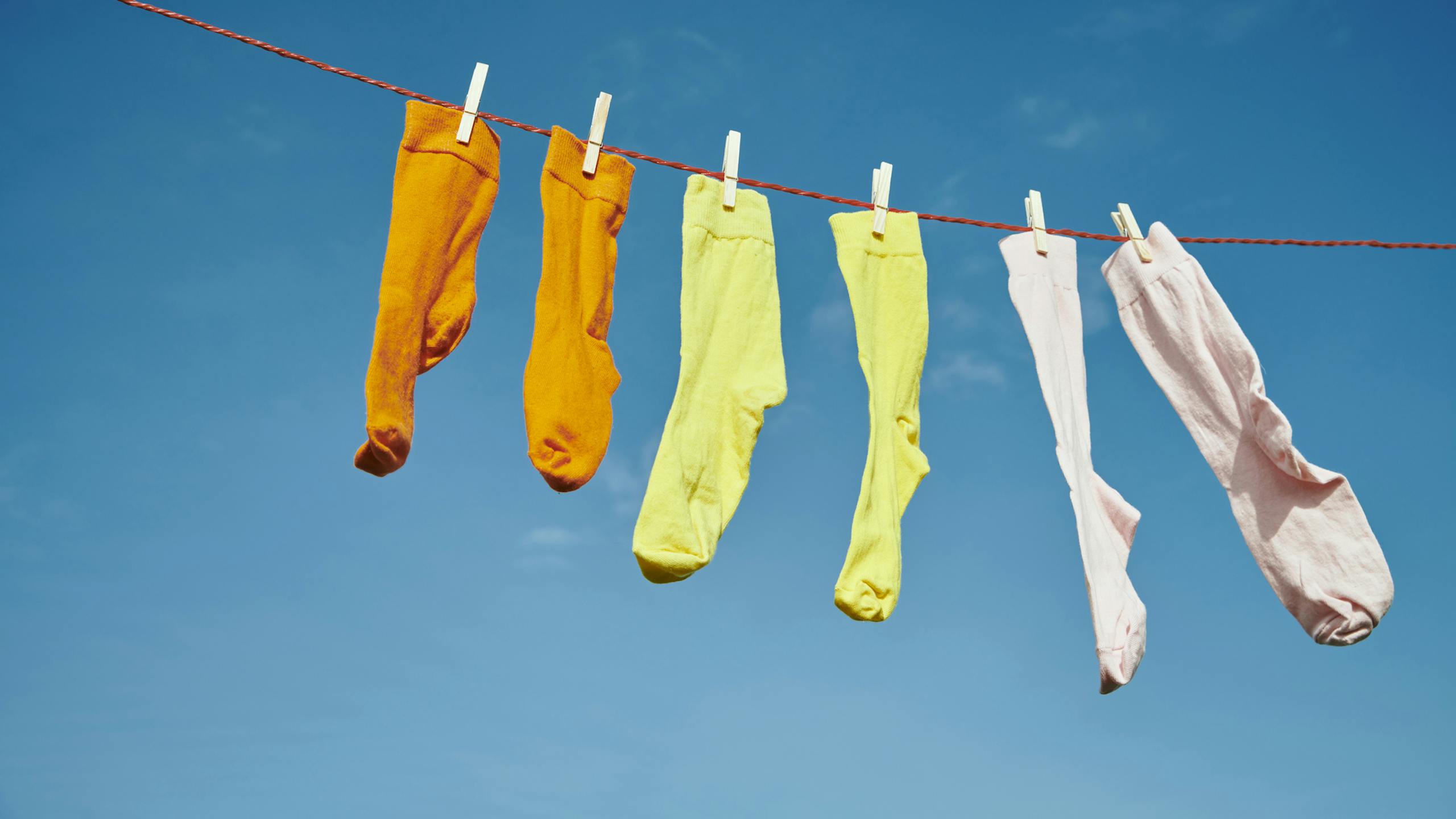 Chaussettes colorées séchant au soleil sur un fil