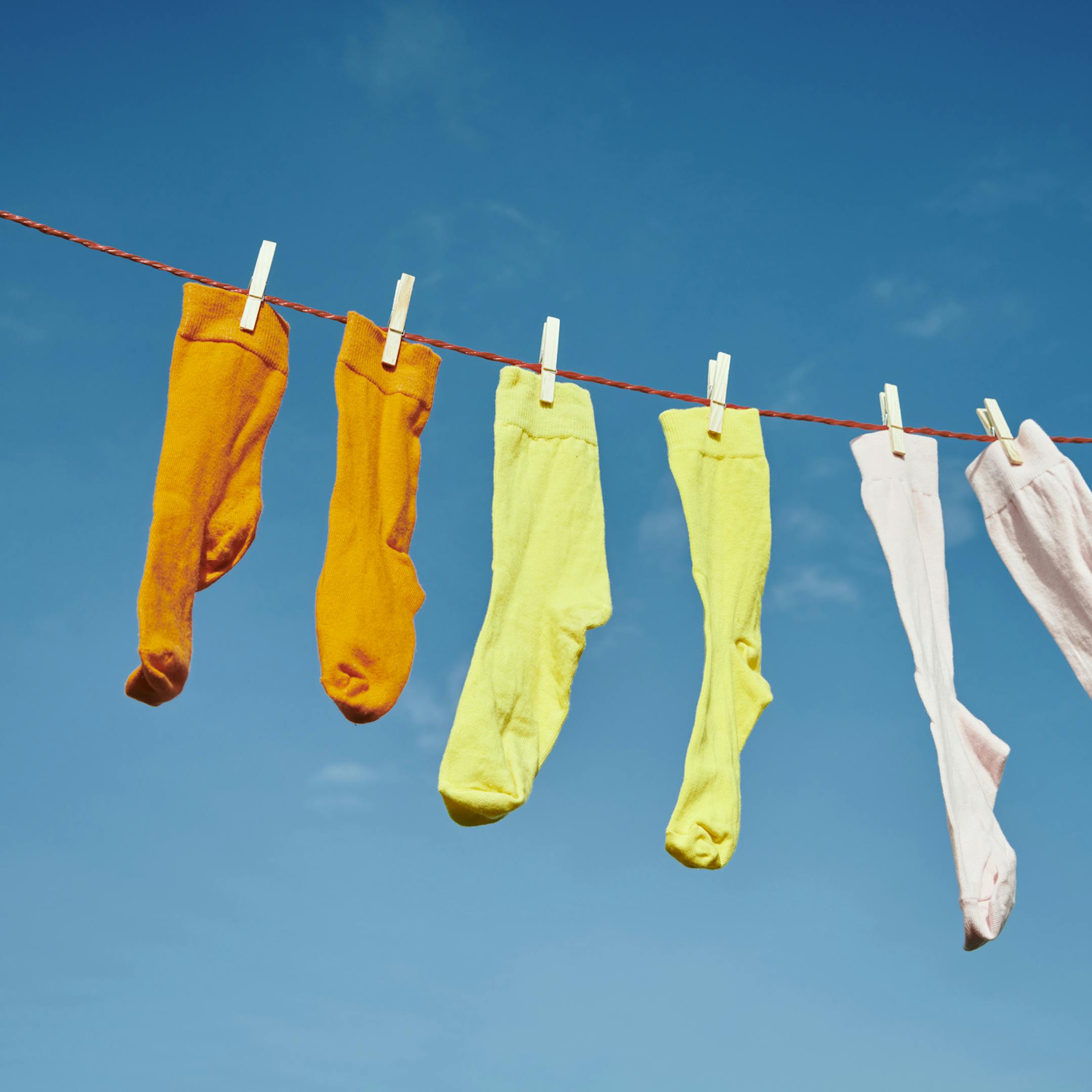 Chaussettes colorées séchant au soleil sur un fil