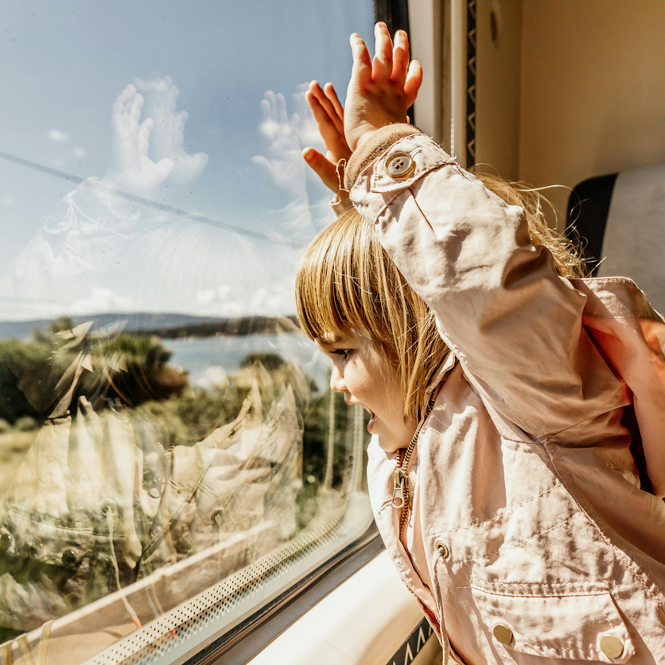 Joyeuse petite fille regardant le paysage depuis le train