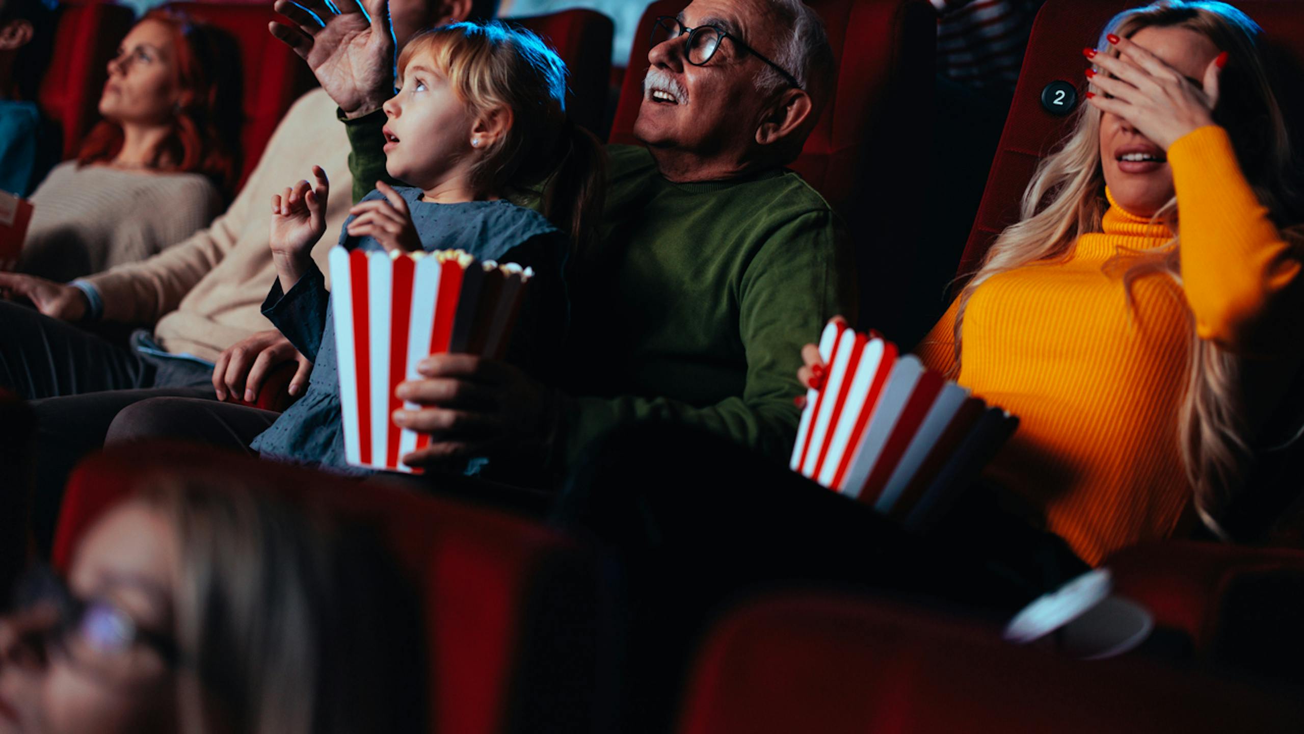 Spectateurs de tous les âges réagissant à un film dans un cinéma