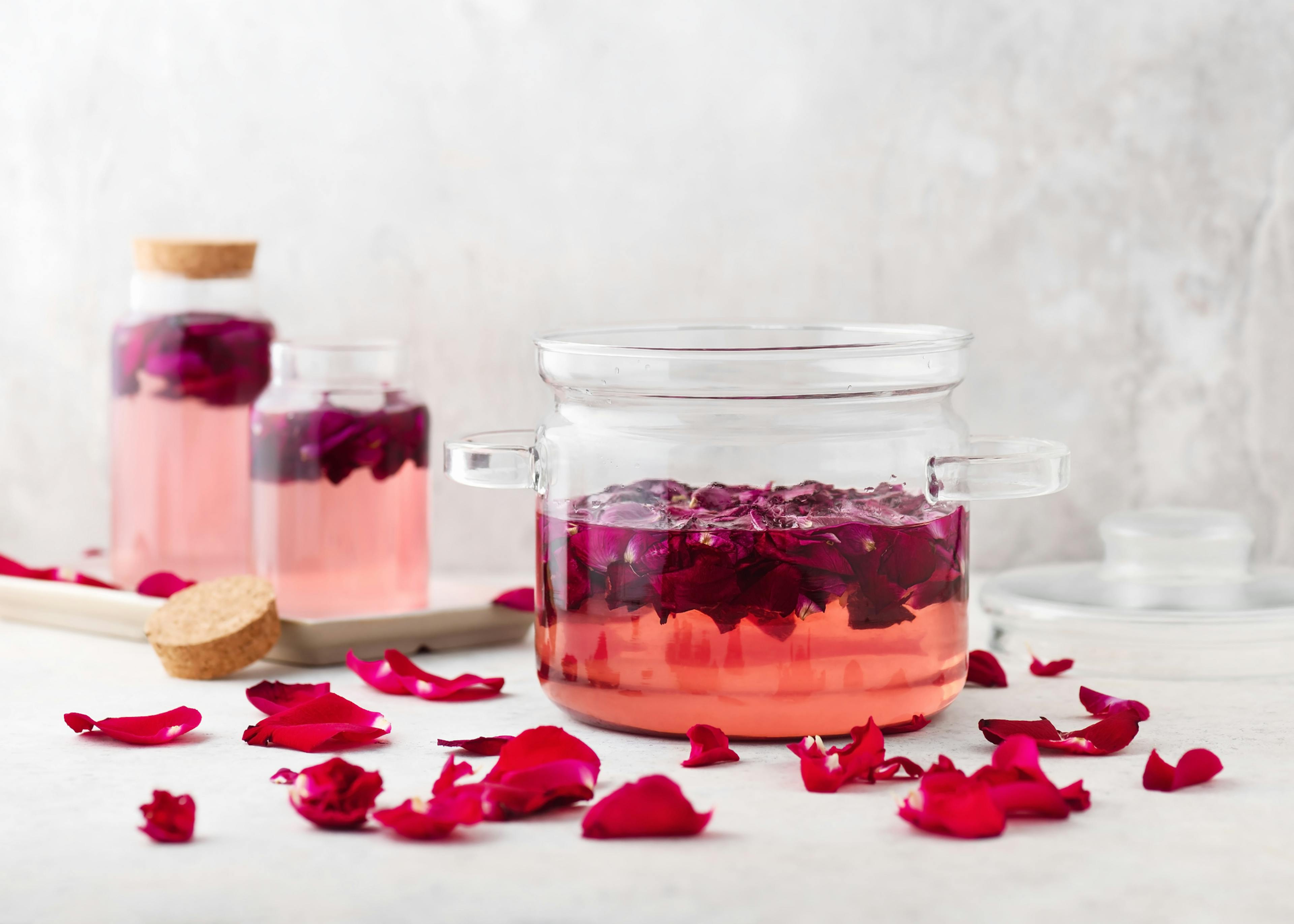 Sirop de rose maison dans un pot en verre avec des pétales biologiques roses