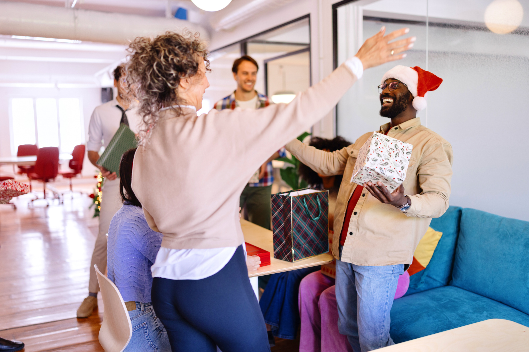 Des collèguent s'offre des cadeaux dans le bureau au moment de Noël