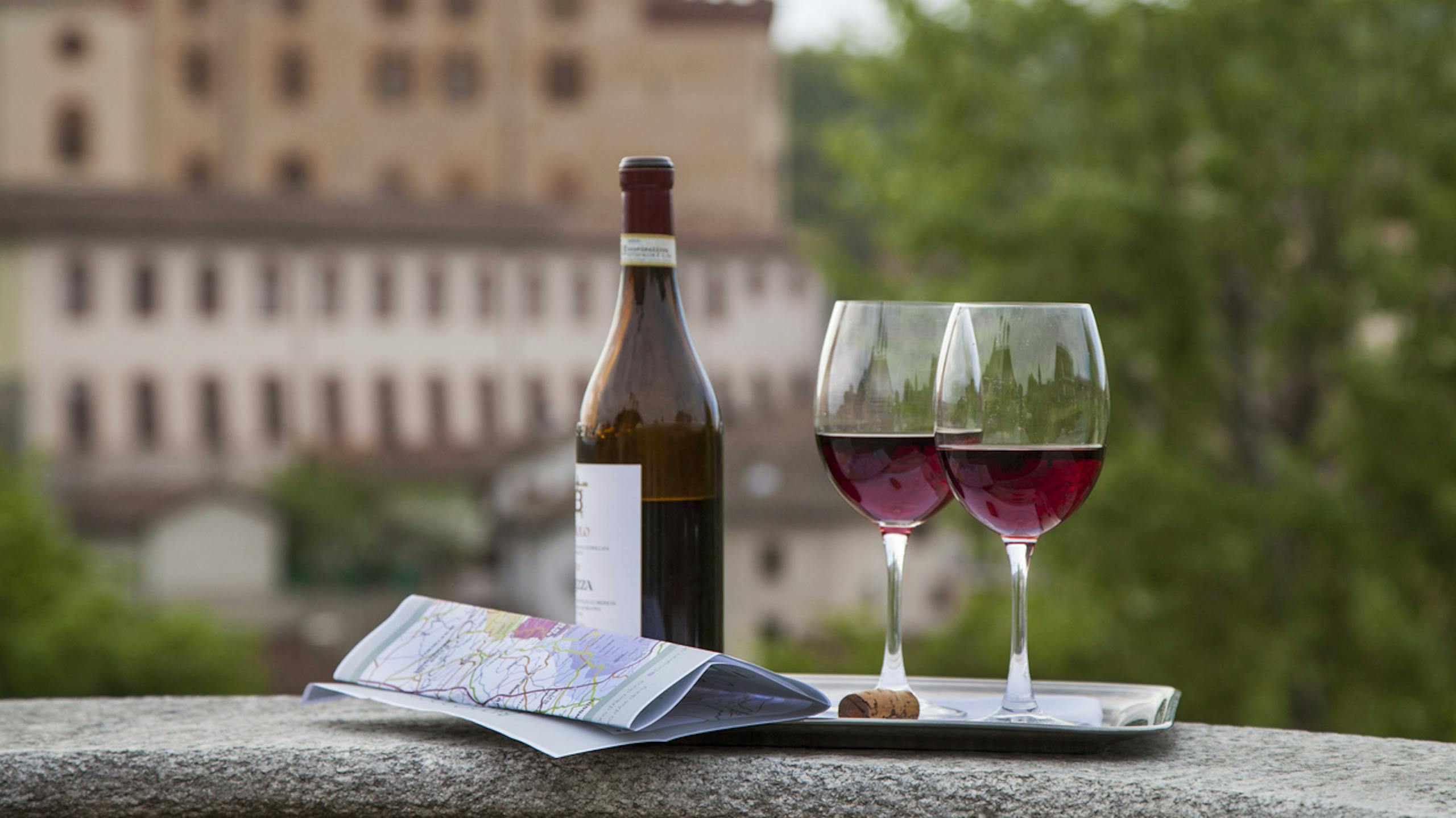 Bouteille de vin accompagnée de deux verres et d'une carte lors d'une dégustation dans un lieu pittoresque