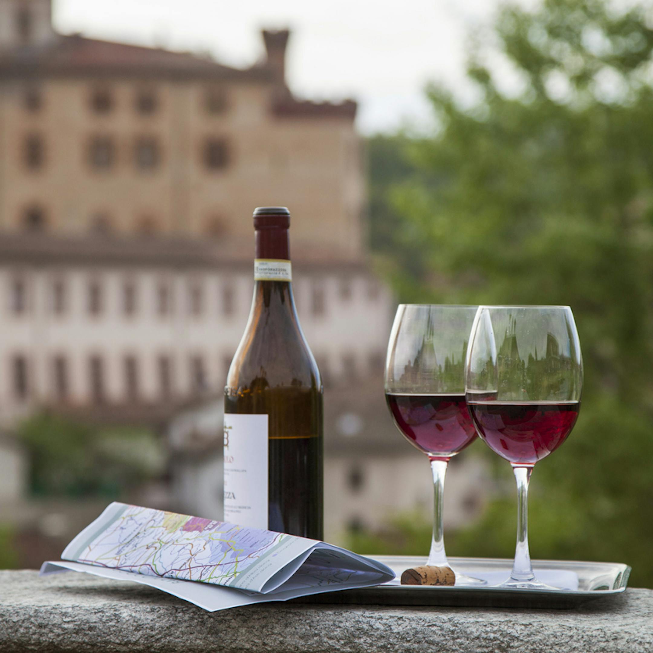 Bouteille de vin accompagnée de deux verres et d'une carte lors d'une dégustation dans un lieu pittoresque