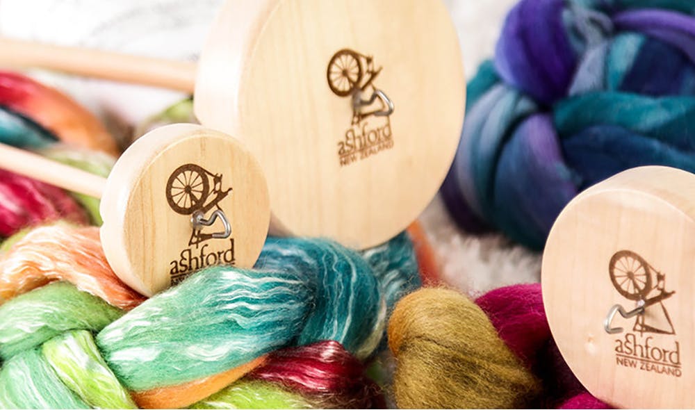 Spinning some hand-dyed wool into yarn using a wooden spinning
