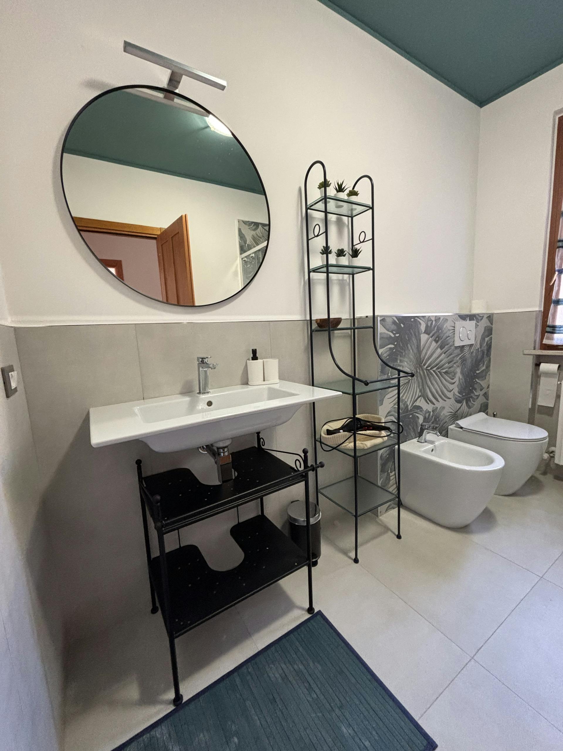Dettaglio del bagno bianco e grigio e dotato di sanitari