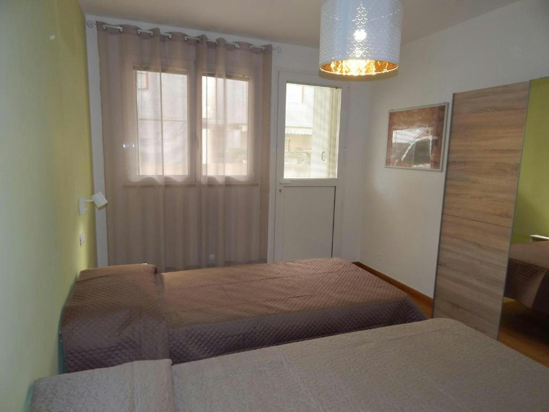 La camera da letto secondaria è sui toni del verde e dispone di due letti singoli