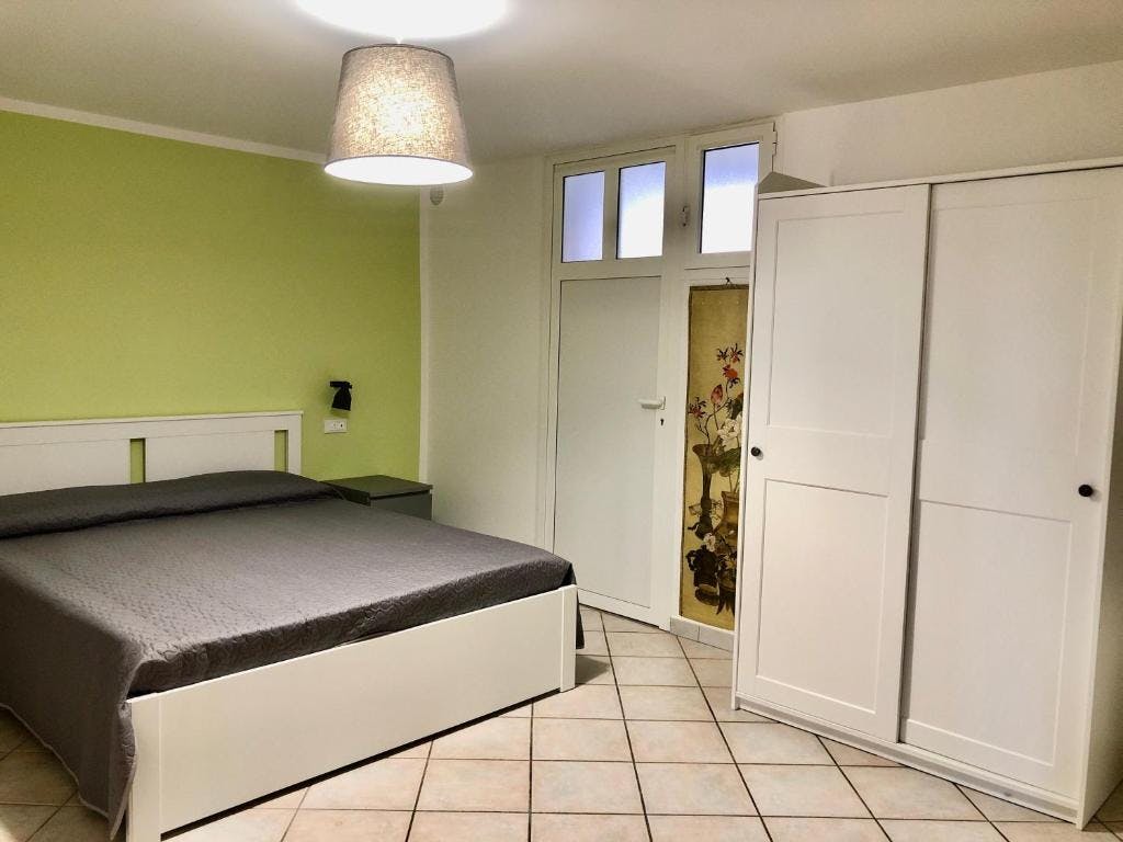 Camera da letto matrimoniale sui toni del verde e con armadio a due ante
