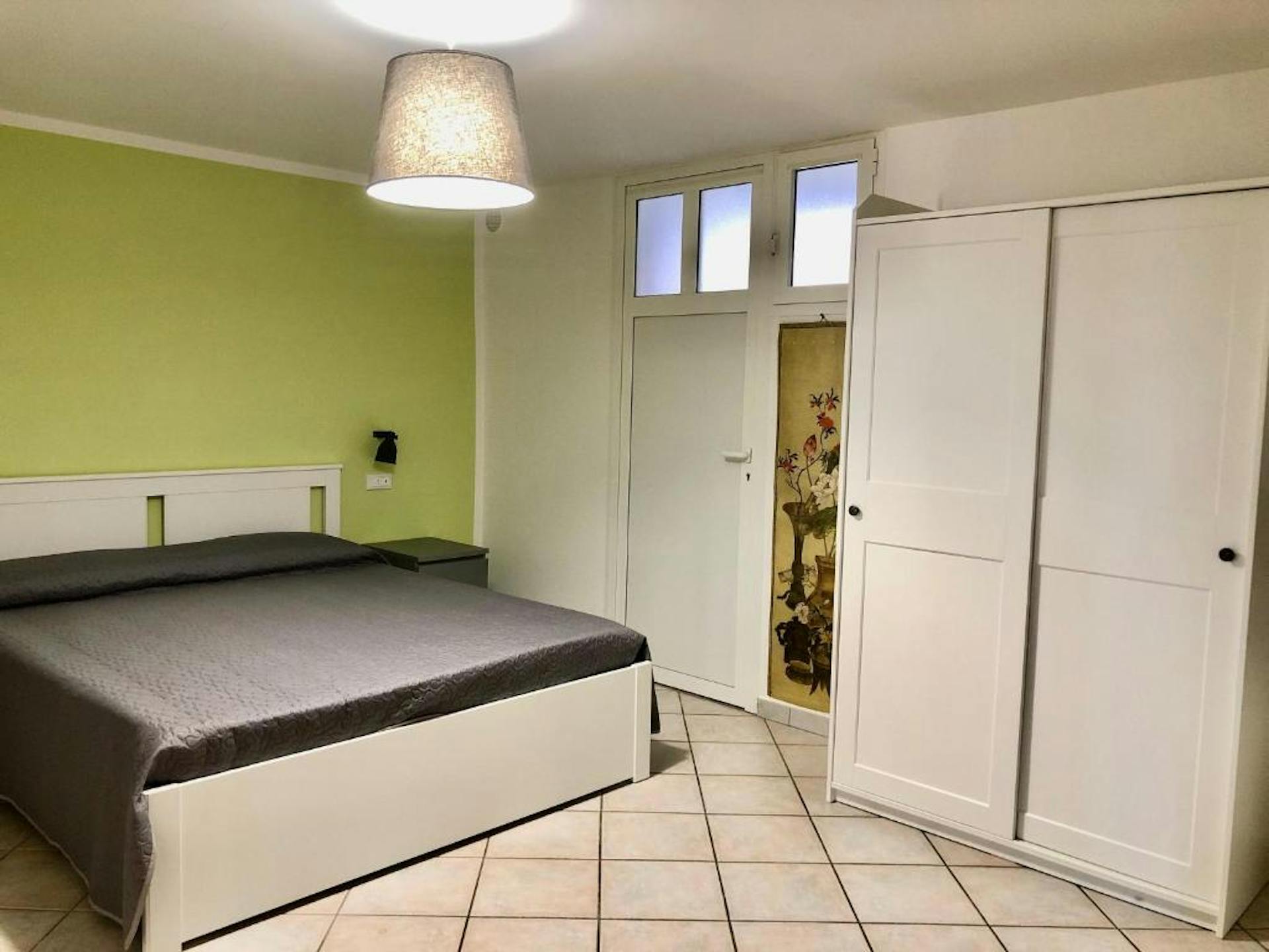 Camera da letto matrimoniale sui toni del verde e con armadio a due ante