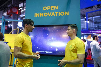 stand vivatech deux postiers devant un panneau open innovation