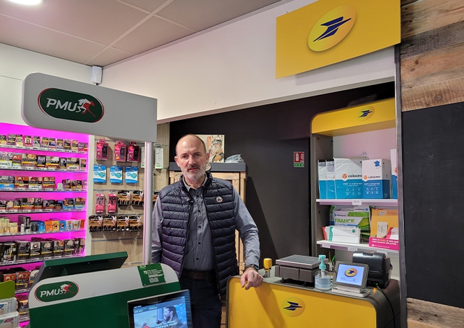 photo d'un facteur-guichetier dans un "La Poste Relais Commerçant (LPRC)"