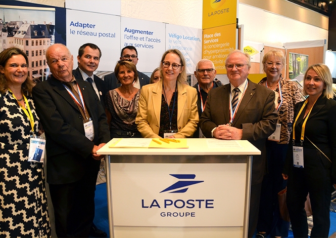 Photo du lancement de la première "Place des Services" à Epône avec plusieurs personnes autour d'un logo La Poste Groupe