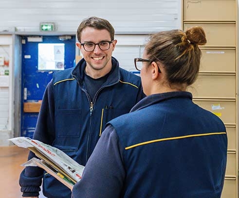two postal workers speaking together