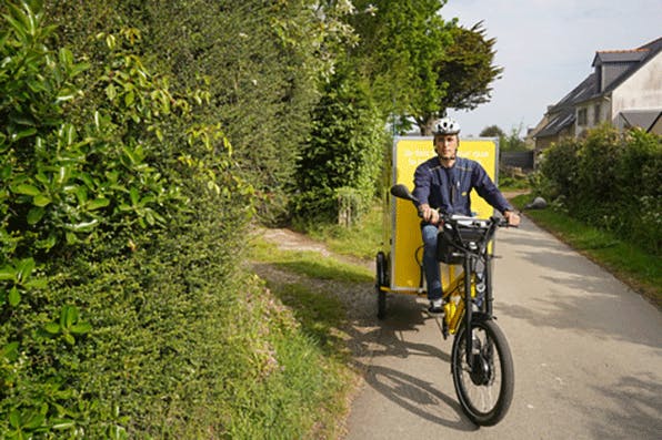 un facteur sur un vélo cargo