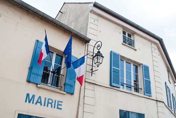 Photo de la façade d'une Mairie en France, avec le drapeau français et le drapeau européen