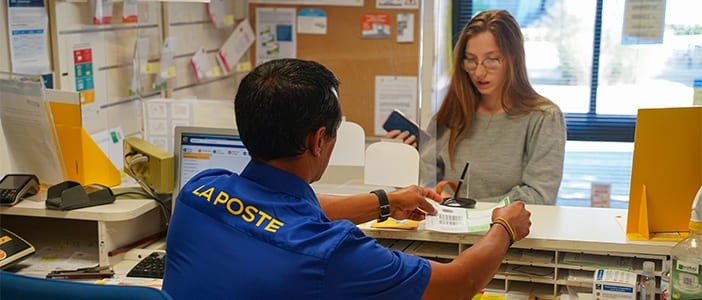 Un postier avec une cliente dans un bureau