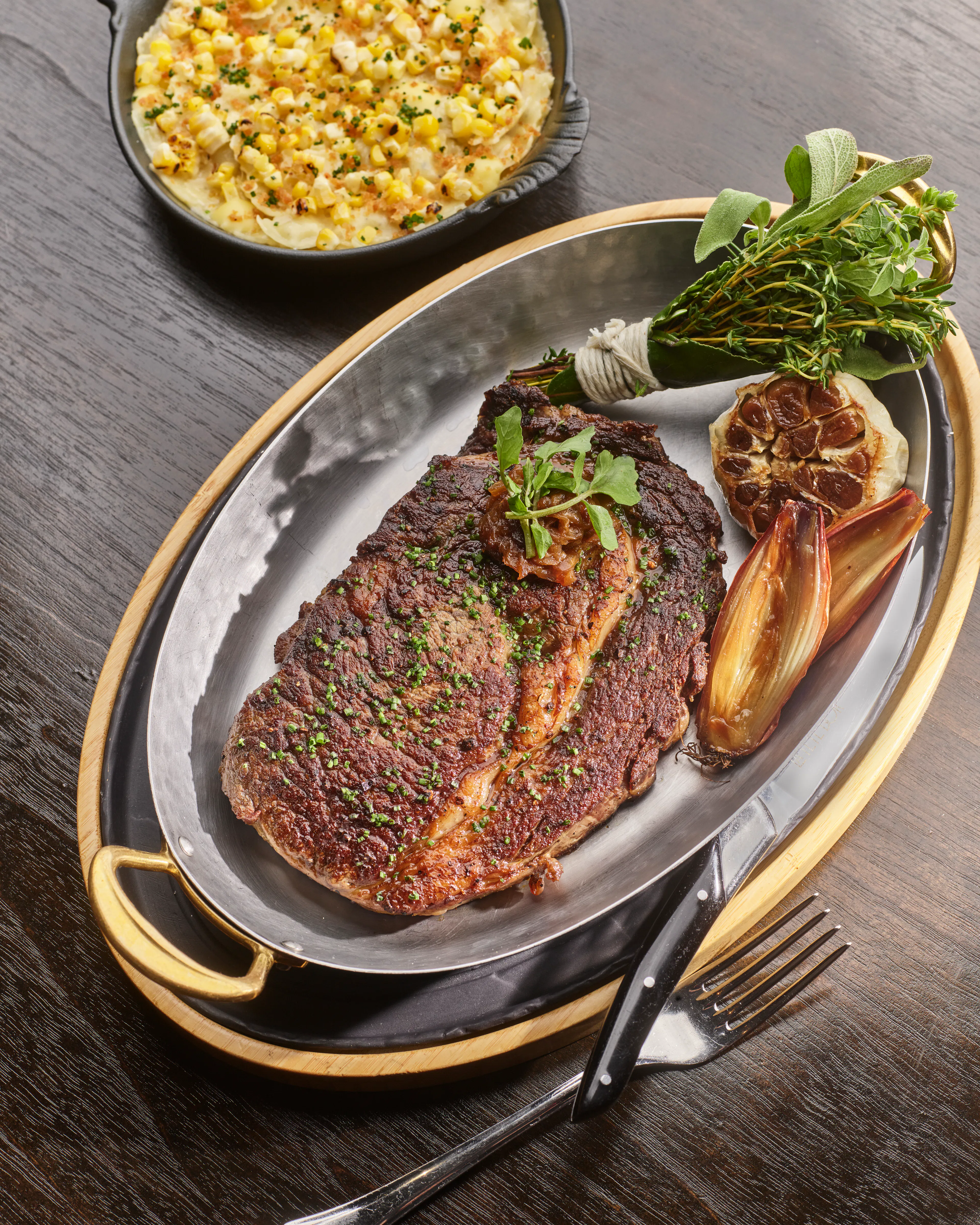Citrus-fed Australian Wagyu striploin served with roasted garlic and herbs, accompanied by truffle ravioli.