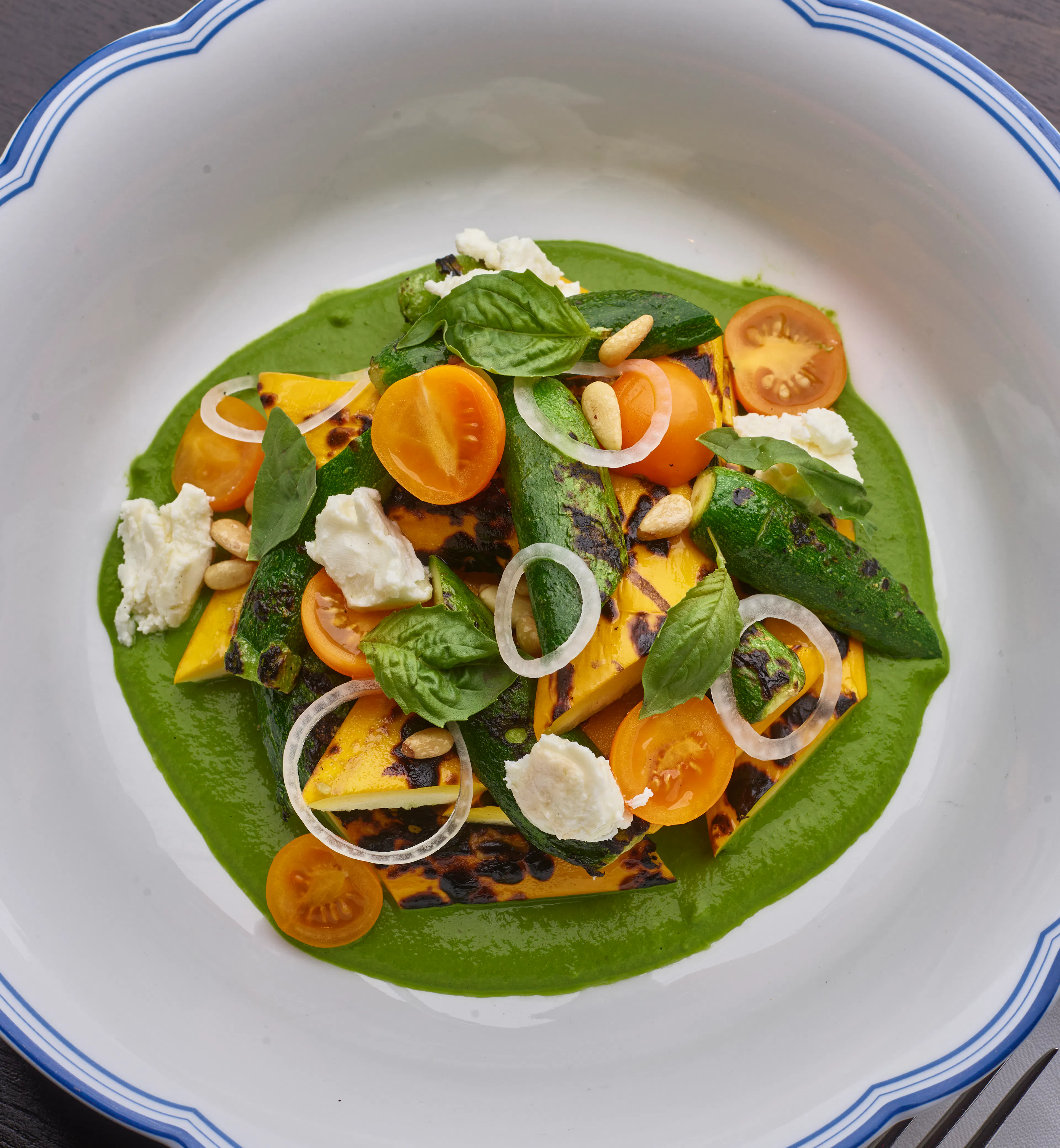 Grilled zucchini with pine nut pesto, Meredith feta, tomatoes, fresh basil, and toasted pine nuts.