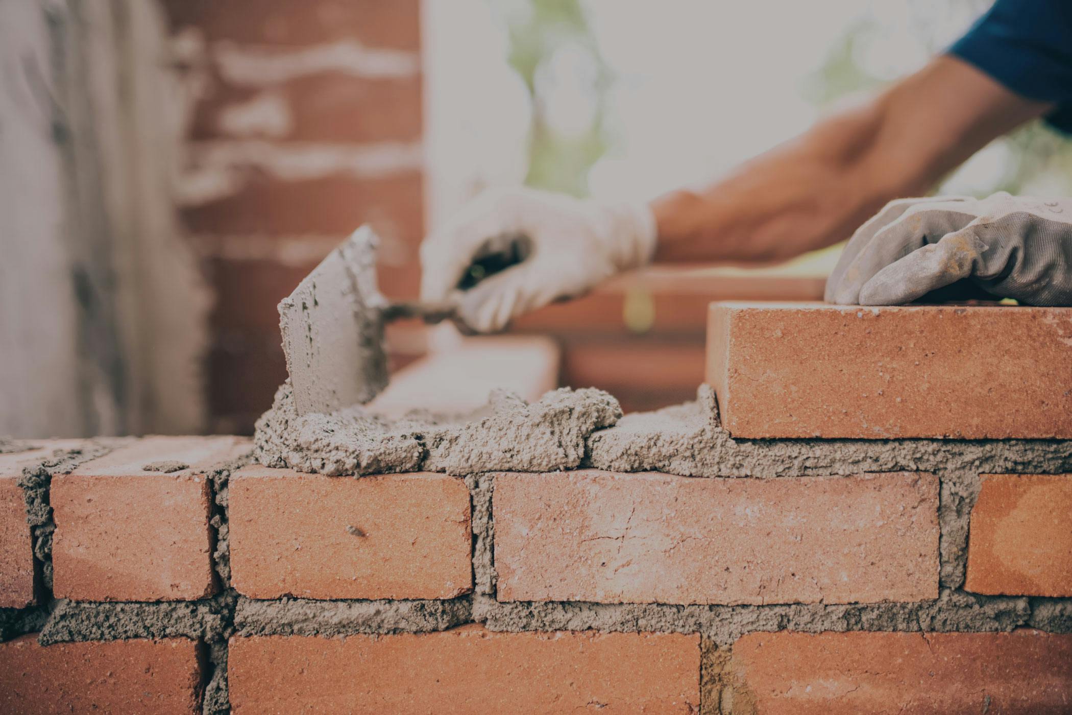Photo: person stacking a brick wall