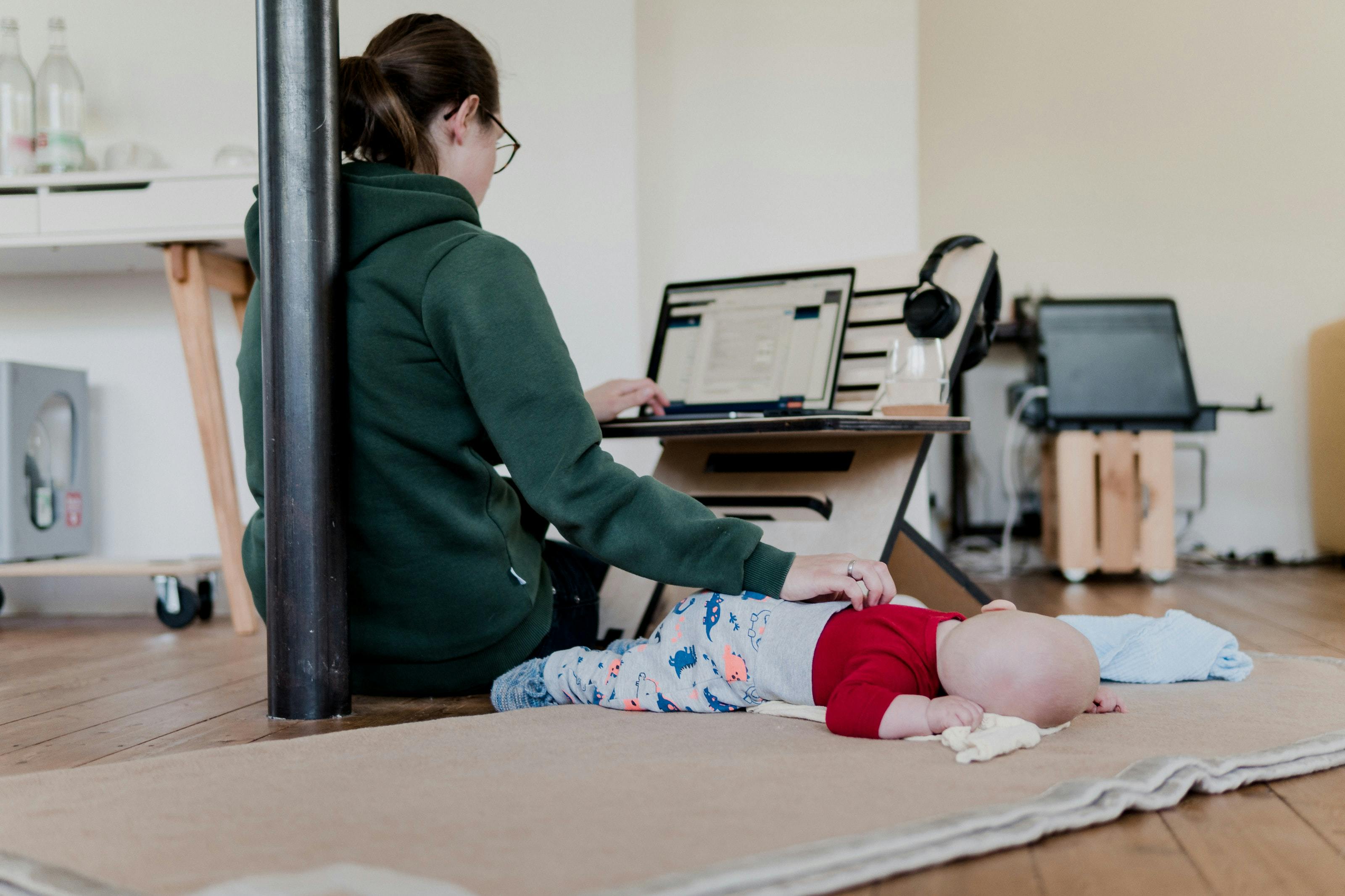 Woman working from home while caring for a child