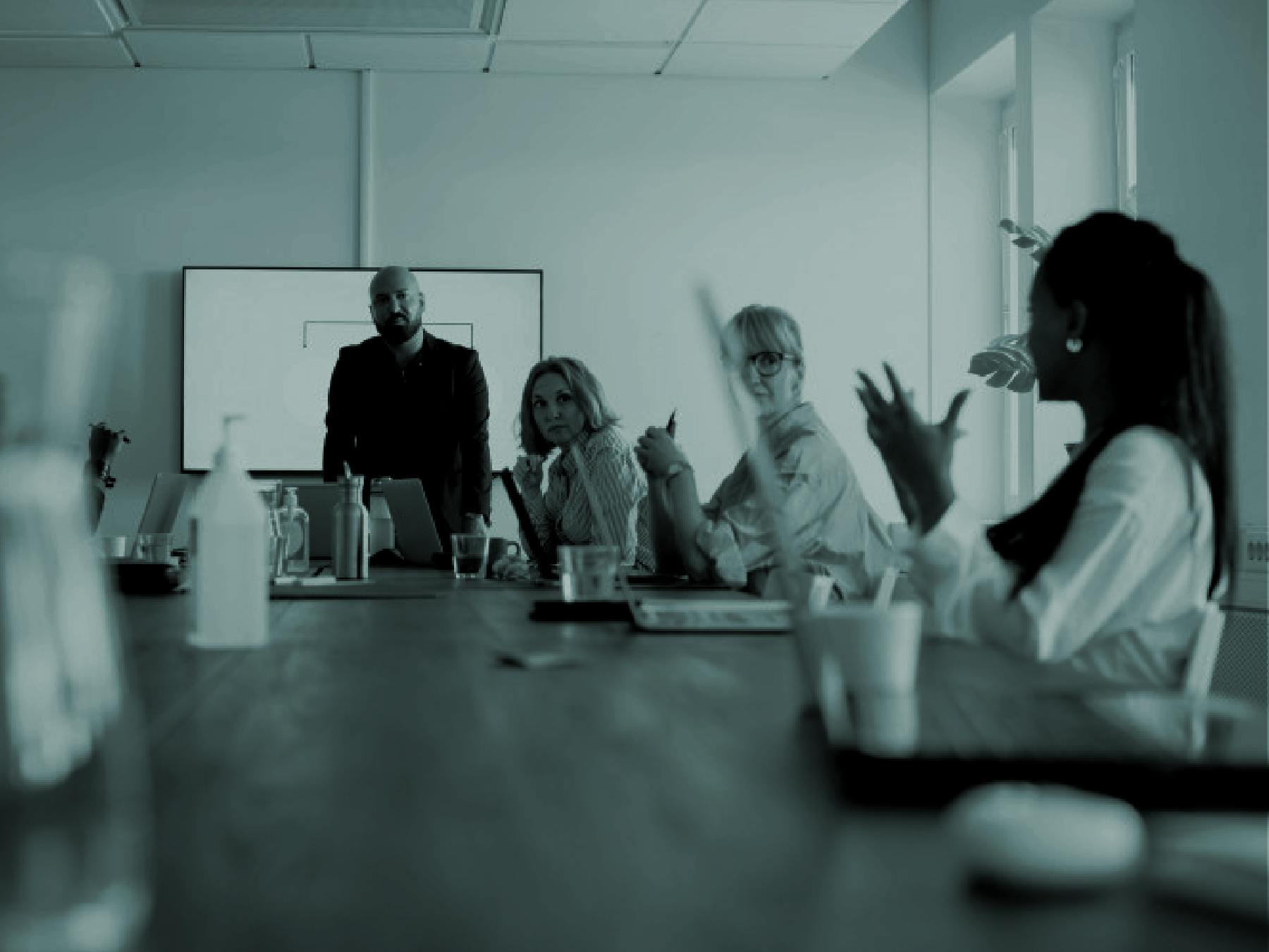 Group of employees gathered around conference table engaged in conversation