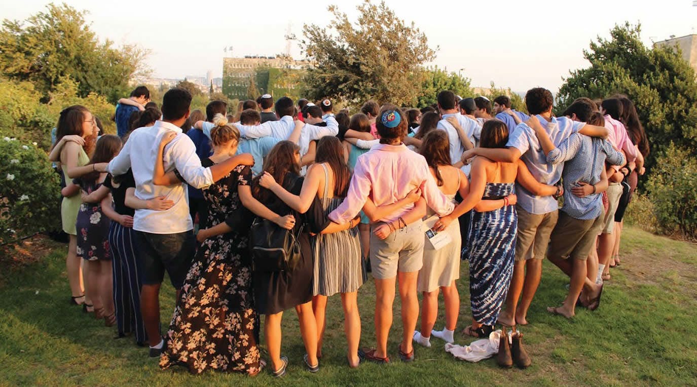 BBYO staff standing in a circle with their arms around each other
