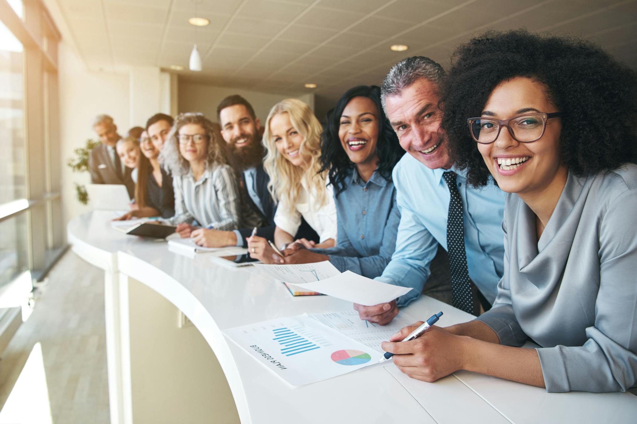 Group of smiling coworkers posing for a picture in the office.