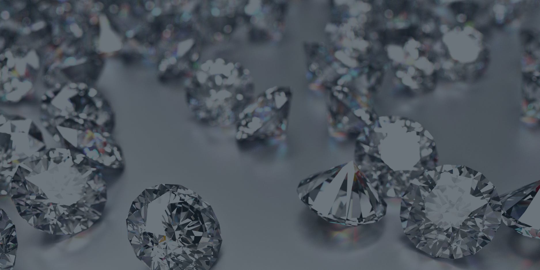 A close-up image of numerous sparkling diamonds scattered across a smooth surface