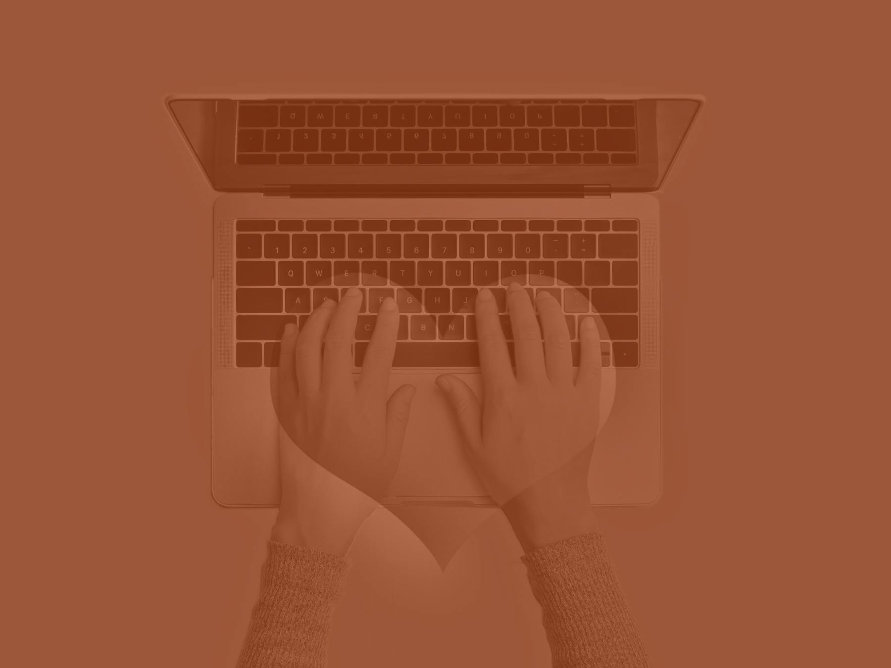 Hands type on a laptop keyboard with a heart shape overlay.