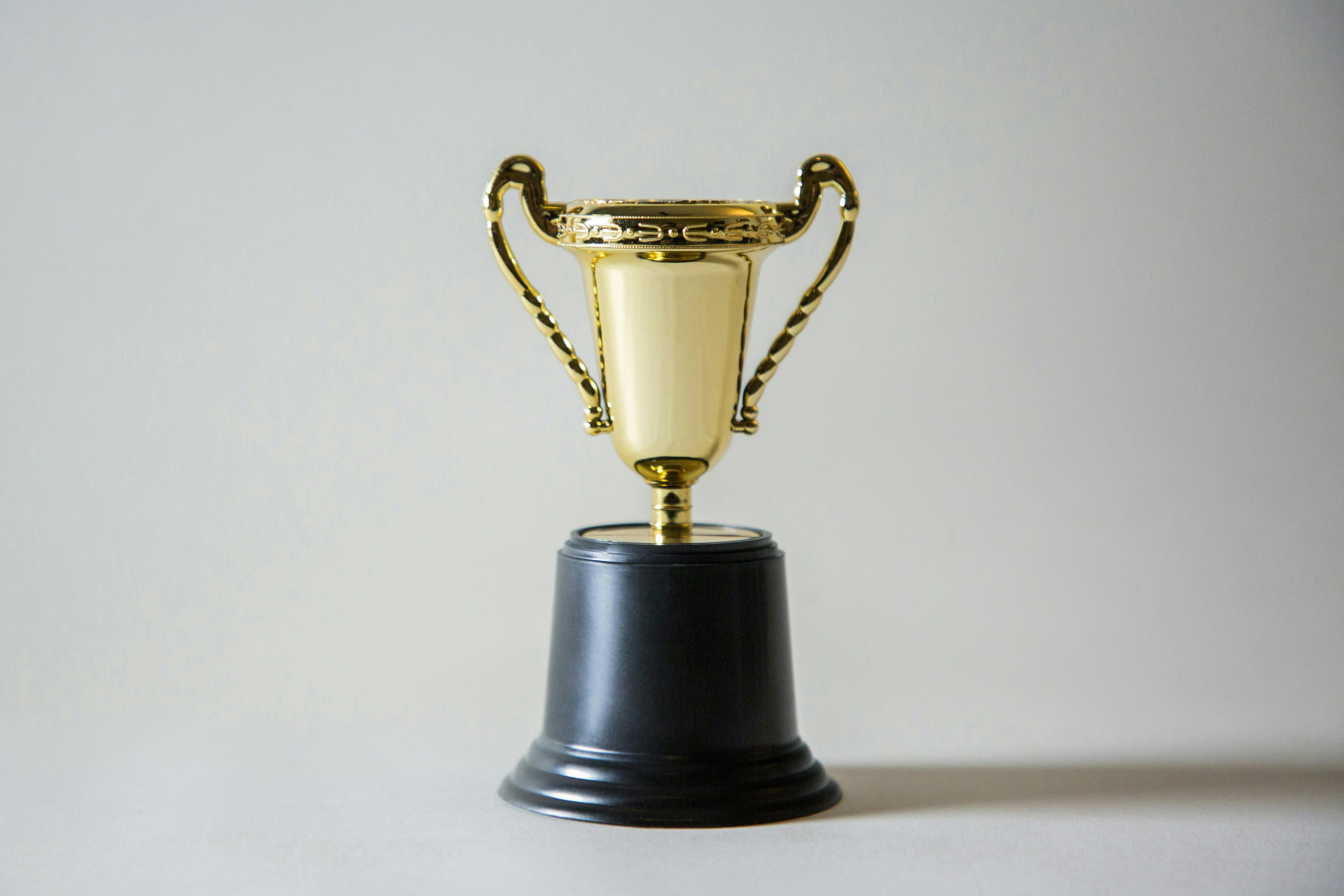 A gold trophy with a black base against a plain white background.